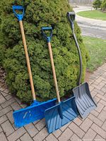 Three shovels grouped: two blue wooden-shaft, one gray ergonomic
