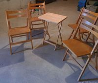Group view of four folding chairs and tray table