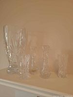 All five crystal vases grouped together showing relative sizes and patterns
