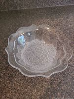 close view of serving bowl showing etched floral design and scalloped rim