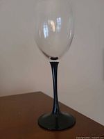 Single clear bowl wine glass with black stem and base