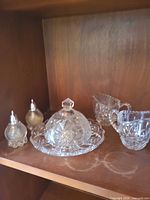 Full set on shelf showing butter dish, two creamers, salt and pepper shakers