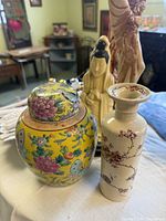 Ginger jar, vase, and Guanyin figurine grouped on table