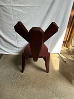 Front view of wooden chair with three-panel backrest and angular seat