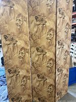 Full view of front of three hinged panels showing lion motif