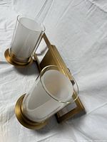 Assembled sconce showing brushed brass finish and double glass shades