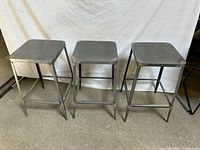 Three matching steel bar stools front view