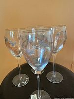 Four LANIA wine glasses showing painted grape design and brand stickers