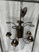 Full view of brass 5-light chandelier, showing arms, socket cups, chain, canopy