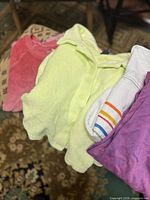 Stack showing coral, neon lime, white stripe and purple tops