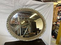 Front view of oval mirror showing frame and glass