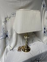 Full view of brass table lamp with shade