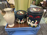Front view showing both duck motif canisters beside reference object