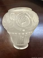 Single shade close-up showing frosted finish, rose relief, and fitter opening