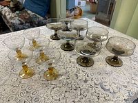 Group of 10 vintage coupe glasses showing amber-stem and smoke variants