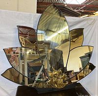 Front view of lotus mirror showing smoked glass panels and brass base