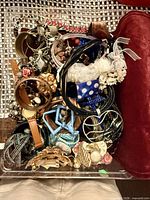 Top view of clear box showing assorted bracelets, bangles, necklaces, headbands and other costume jewelry pieces