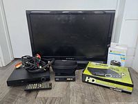 Front view of Dynex TV, DVD player, cables, remote, receiver, accessory pouch and packaging