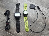 Both Garmin watches and two chargers laid out