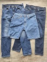 Two jeans and one jean short laid out front view