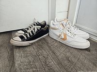 Both pairs of Converse sneakers side by side on floor
