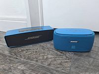 Rectangular Bose SoundLink Mini and rounded Bose Smart Music K3 speakers side by side