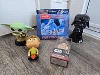 All items together: three bobbleheads, Coca-Cola playing cards tin, BB-8 USB drive