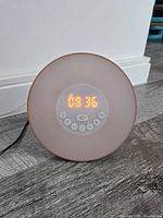 Front view showing time display and buttons with warm white light