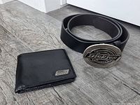 belt coiled next to wallet displaying front surfaces