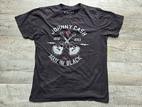 Full front view of black Johnny Cash graphic T-shirt laid flat