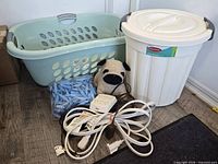 All items grouped: laundry basket, garbage can, weighted pug doorstop, clothespins, extension cords