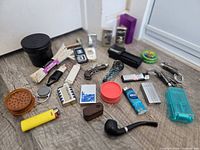 Full lot overview on floor with various lighters, pipes, grinders, containers