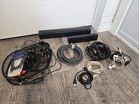 Coiled cables, soundbars and accessories on floor