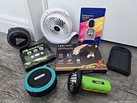 Group shot of all items: fans, speakers, power banks, ring stand, LED gloves