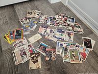 overview of mixed sports trading cards spread on floor