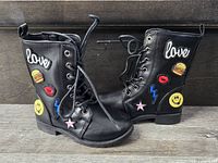 Side view of both boots showing embroidered patches and overall design