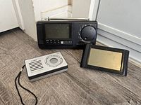 Group shot of Oregon Scientific radio, Coby pocket radio, digital alarm clock