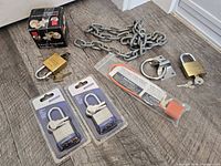 Full lot overview showing chain, padlocks, deadbolt box, anchor plate and cable lock