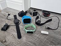 Group shot of all smart watches, fitness trackers, chargers and dongle on surface