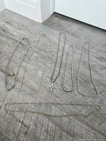All six necklaces laid out with crucifix pendant visible