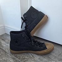Side view of both black Converse high-tops showing canvas uppers and gum rubber outsoles