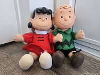 Both Charlie Brown and Lucy dolls seated side by side