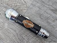 Entire flashlight side view showing leather wrap and logo