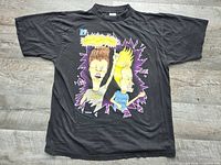 Full front view of black graphic T-shirt laid flat