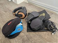 Group shot of three headphone sets with cases and cable visible