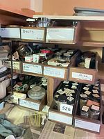 Shelves with labelled drawers containing numerous jars of assorted hardware fasteners