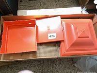 Orange plastic base, roof, metal floor grate in box