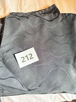 Stacked black cloth napkins with wavy pattern