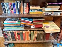 Three-shelf bookcase filled with mixed hardcover and paperback titles