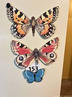Three butterfly magnets displayed on refrigerator door